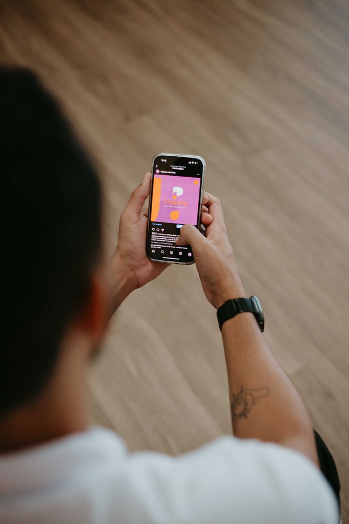 An individual using a smartphone indoors, engaging in mobile application interaction.